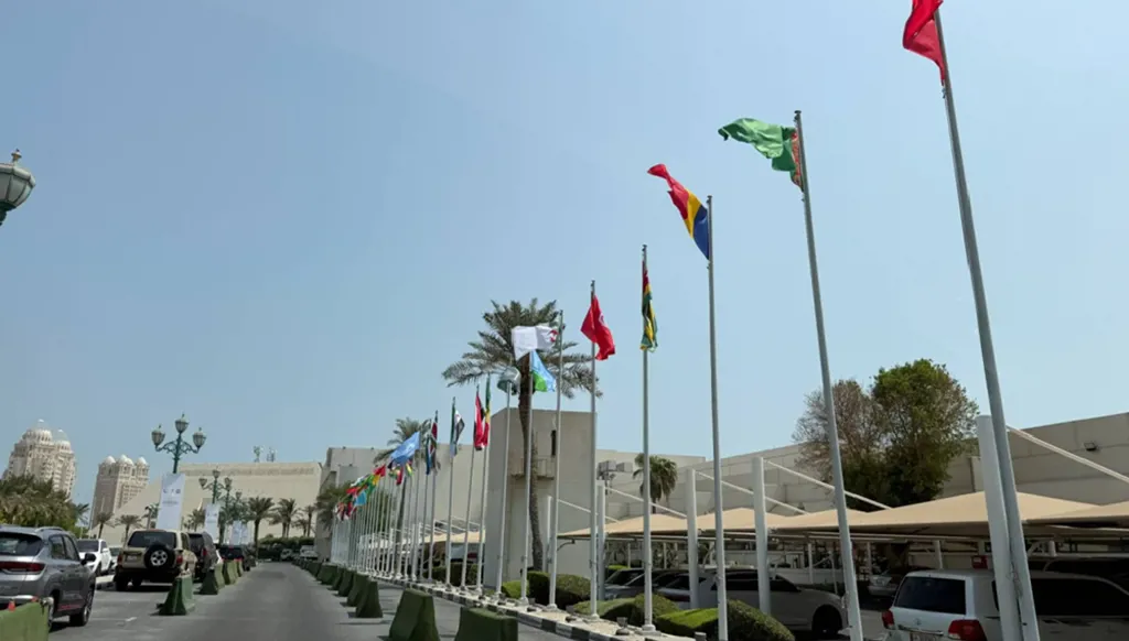 ترفرف الأعلام العربية والإسلامية بينما تستعد قطر لاستضافة القمة الطارئة في فندق شيراتون بالدوحة (رويترز)