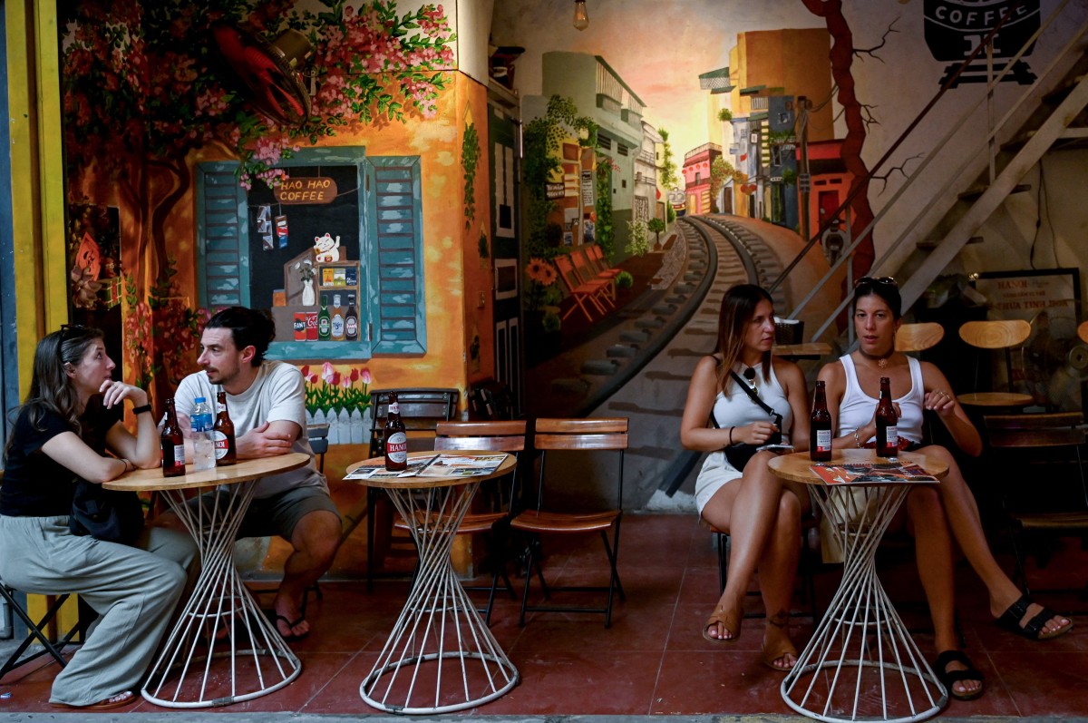 سياح في مقهى بجوار خط سكة حديد في وسط هانوي (أ ف ب)‏