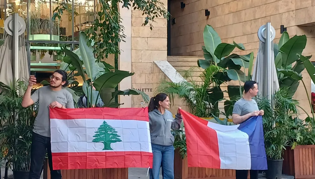 رفع العلمَين اللبناني والفرنسي في منطقة الجميزة بالعاصمة بيروت، قُبيل وصول ماكرون