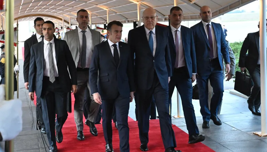 الرئيس نجيب ميقاتي مستقبلاً الرئيس الفرنسي إيمانويل ماكرون على أرض مطار بيروت الدولي (تصوير الزميل نبيل اسماعيل)