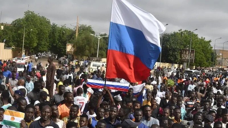 Protesters raising the Russian flag on Independence Day in Niamey on August 3, 2023. (AFP)
