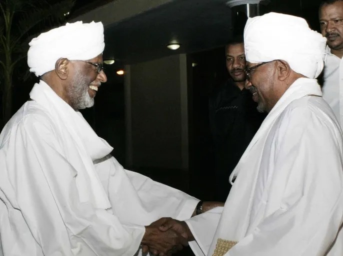 عمر البشير أثناء استقباله حسن الترابي في أول لقاء من نوعه منذ ما عرف بالمفاصلة بين الإسلاميين، عام 2014. (رويترز)