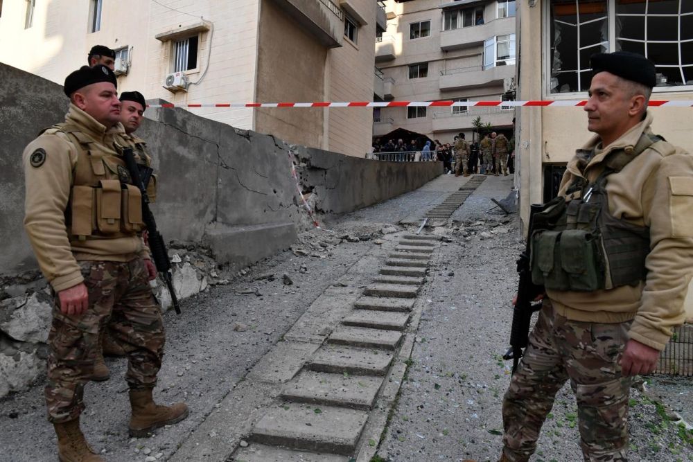 جنود من الجيش اللبناني خلال معاينتهم لآثار شظايا الصاروخ التي سقطت في ساحل علما أمس. (حسام شبارو)