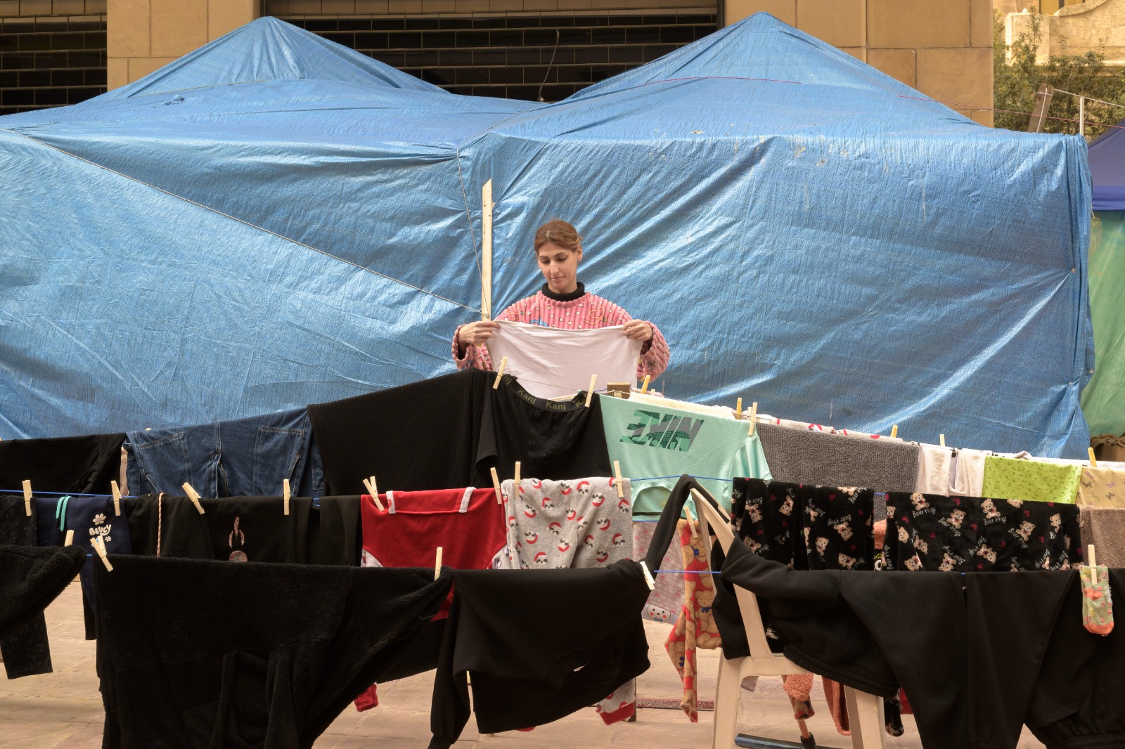 نازحة تنشر الغسيل في أخد مراكز النزوح في بيروت