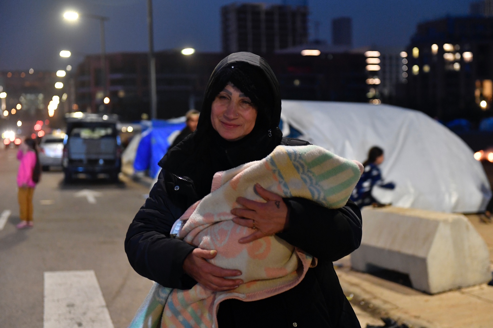 تحمل ابنها خارج أحد مراكز النزوح في بيروت