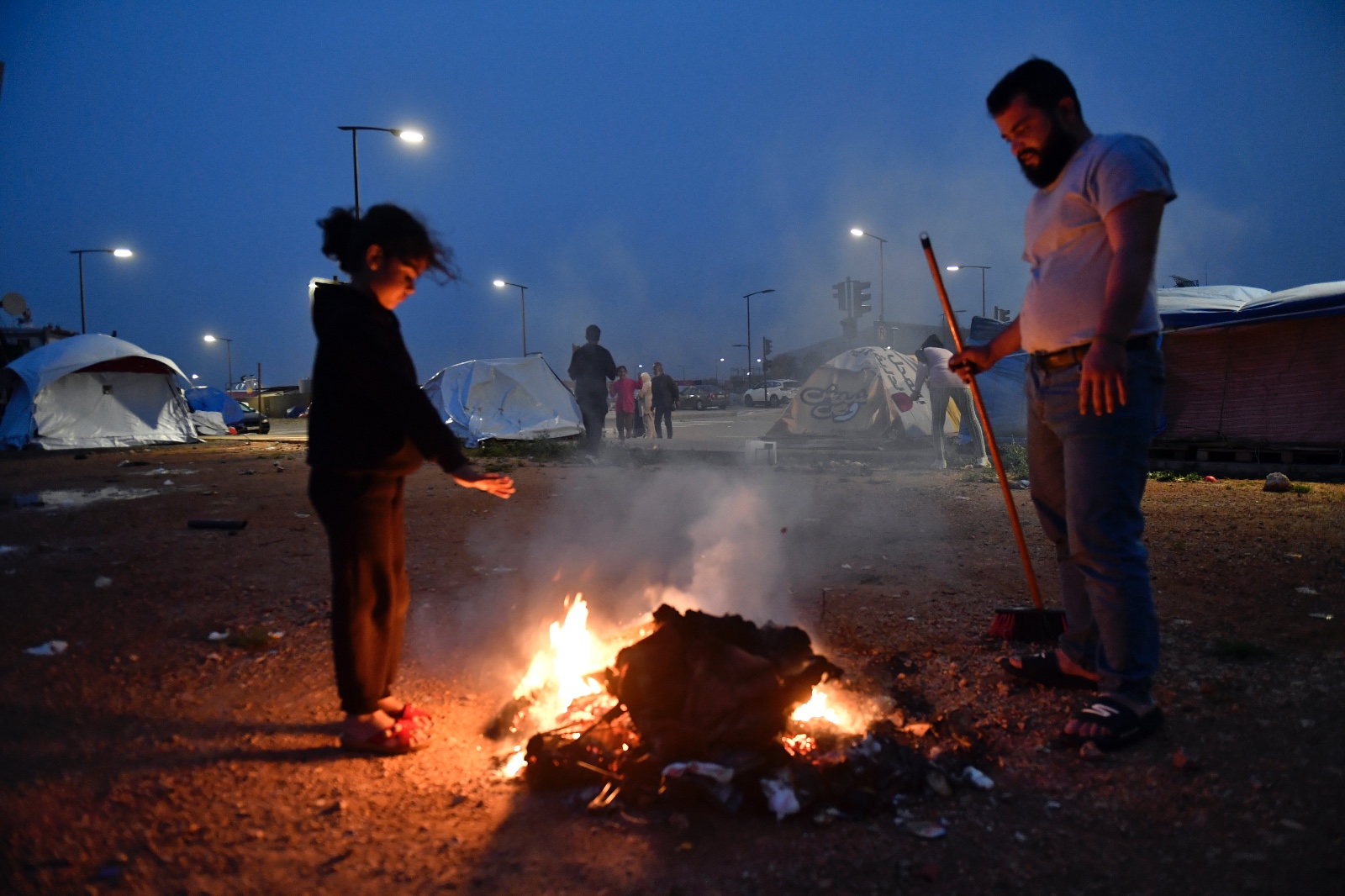 نازحان في محاولة للتدفئة وسط طقس بارد