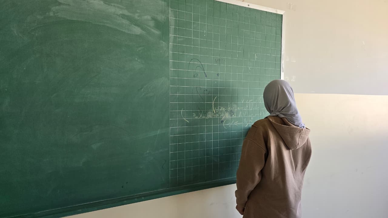 نازحة تكتب على اللوح في صف تحوّل مأوى في بعلبك