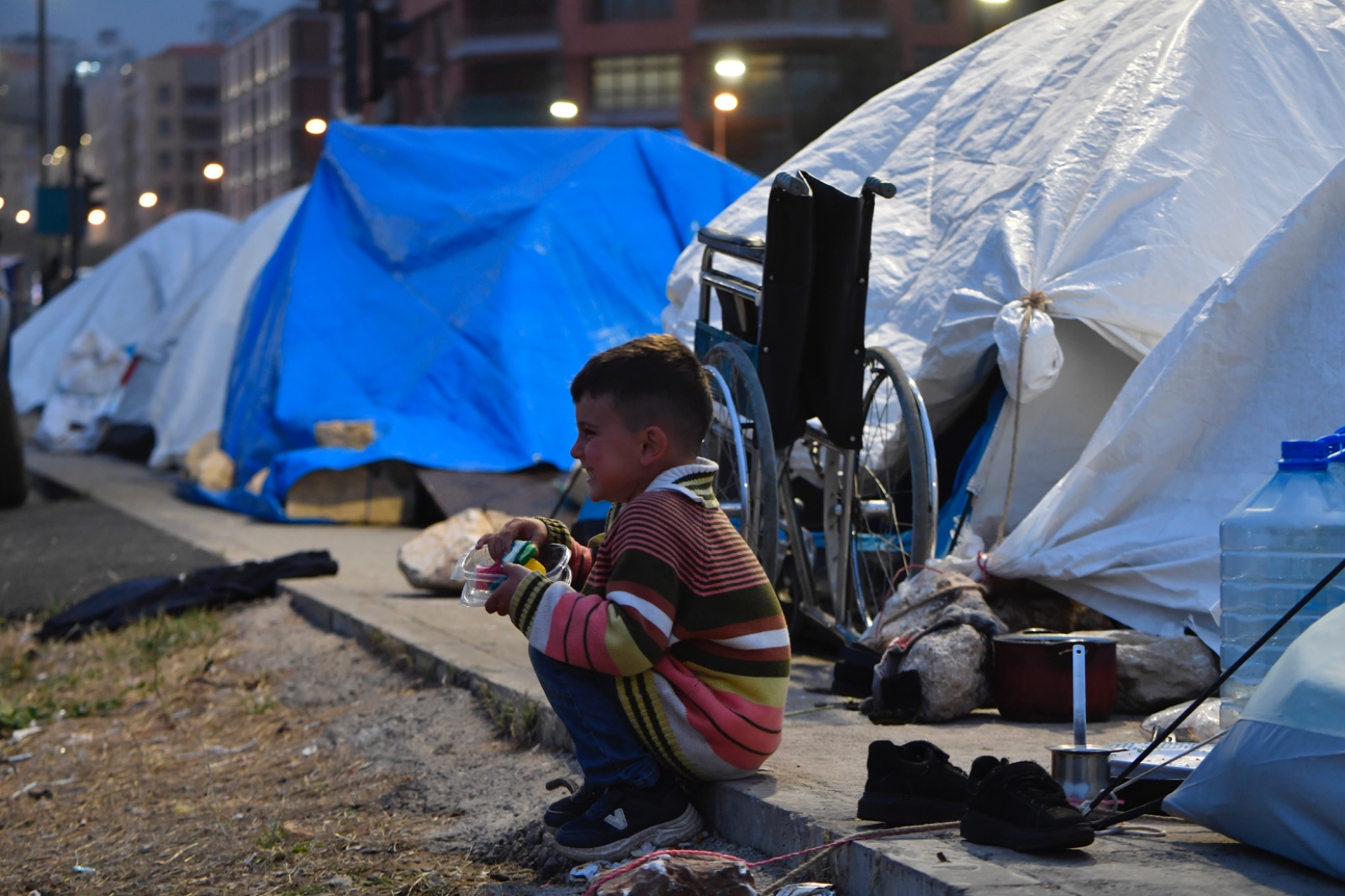 طفل يجلس على حافة الطريق