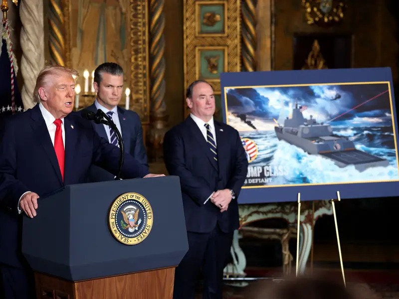 دونالد ترامب خلال إعلان إطلاق بوارج تحمل اسمه، وإلى جانبه وزير الدفاع بيت هيغسيث ووزير البحرية جون فيلان. (أ ف ب)