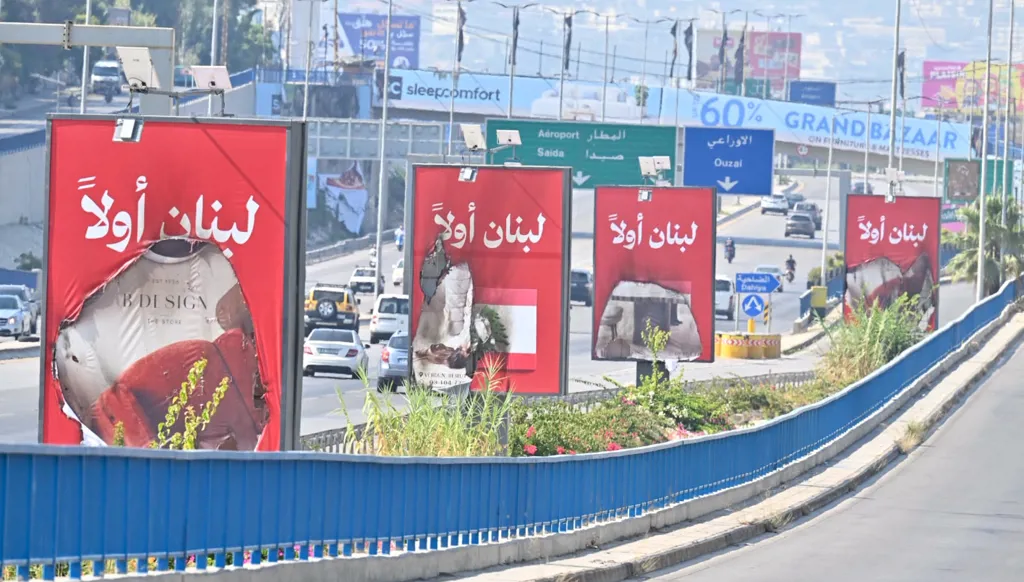 بالصور - إحراق لافتات "لبنان أولاً" و"لبنان بيجمعنا" على طريق المطار