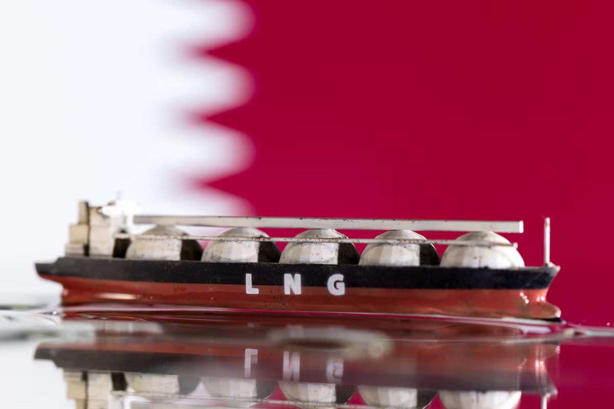 نموذج لناقلة غاز طبيعي مسال أمام علم قطر في صورة توضيحية (رويترز)