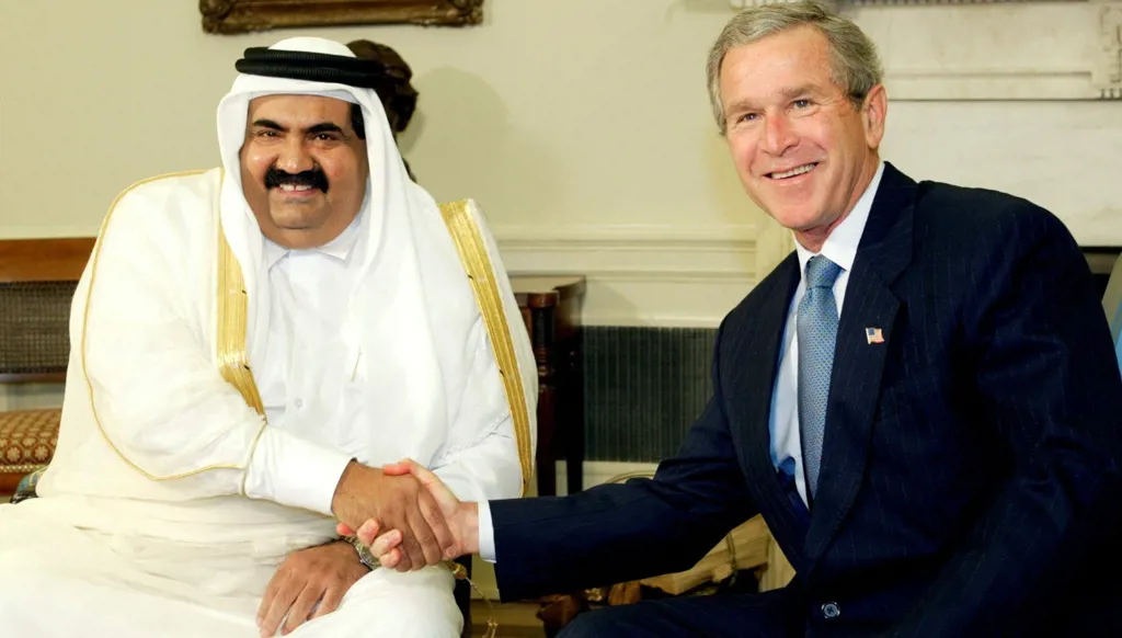 الرئيس الأميركي جورج دبليو بوش يصافح الشيخ حمد بن خليفة آل ثاني في المكتب البيضاوي بالبيت الأبيض في واشنطن، 8 أيار/مايو 2003. (رويترز)