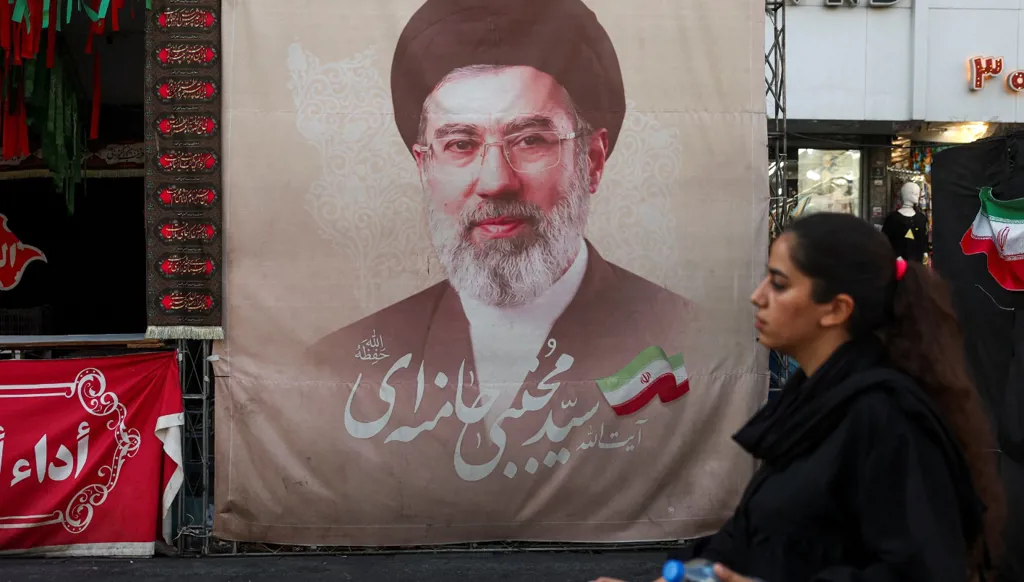 سيدة تمرّ بجانب لافتة تحمل صورة المرشد الإيراني مجتبى خامنئي في أحد شوارع طهران، 13 آب/أغسطس 2026. (رويترز)  