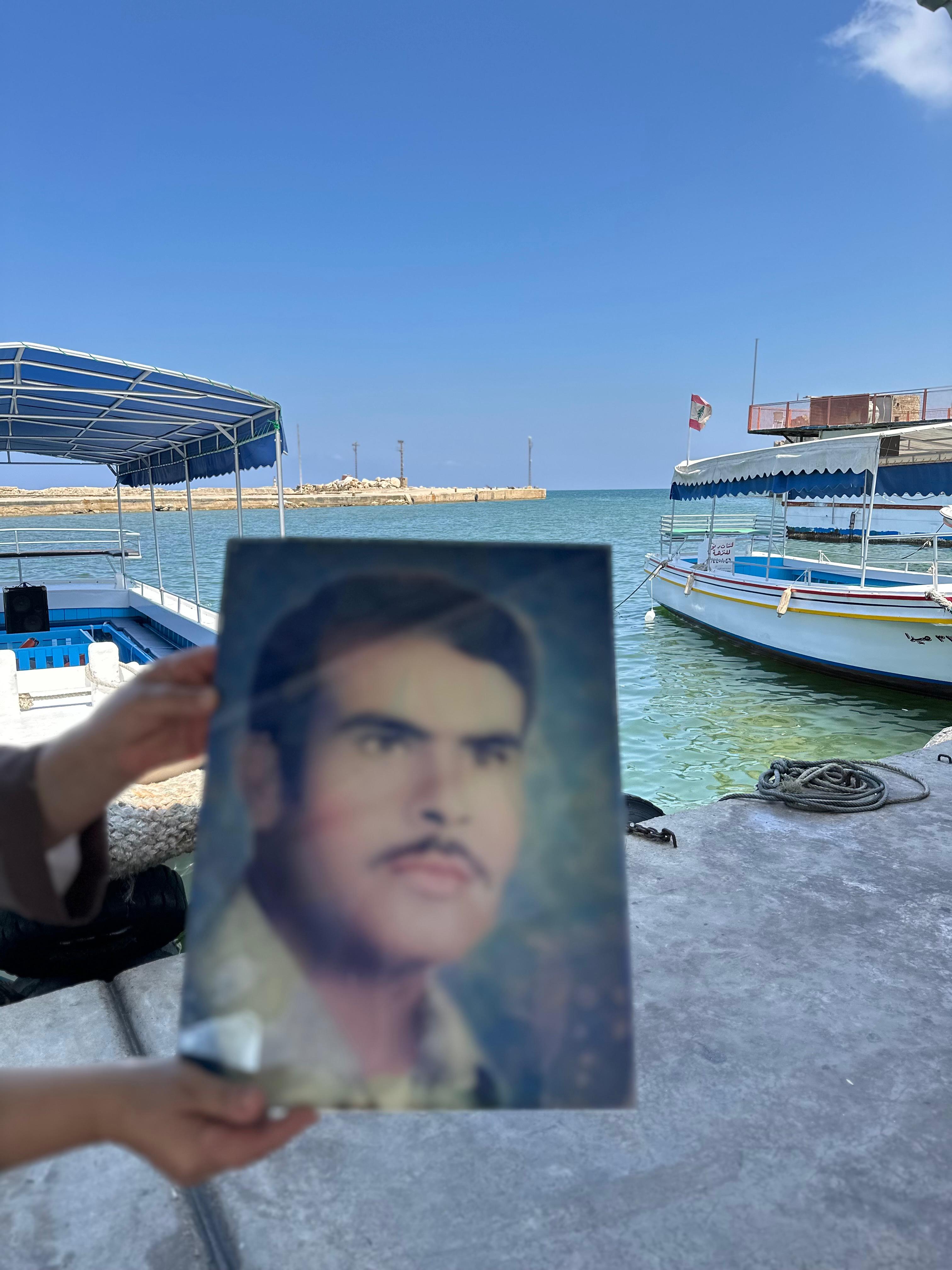 ابنة المفقود رياض الآغا، فردوس، ترفع صورته في المكان الأحب إلى قلبه: ميناء صيدا.
