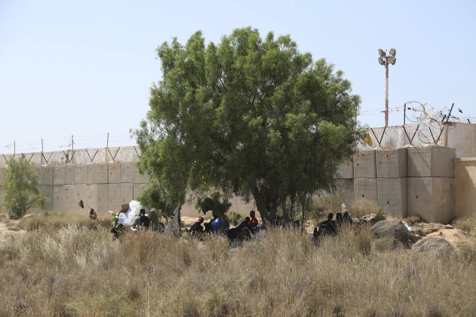 مهاجرون يتجمعون في منطقة صحراوية على الجانب الليبي من الحدود مع تونس في 23 تموز/يوليو 2023 (أ ب).
