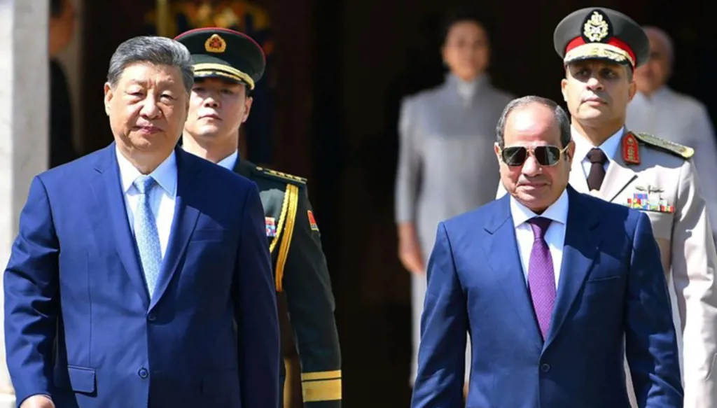 الرئيس الصيني شي جينبينغ (يساراً) يسير إلى جانب نظيره المصري عبد الفتاح السيسي خلال مراسم استقباله في قصر (أ ف ب).