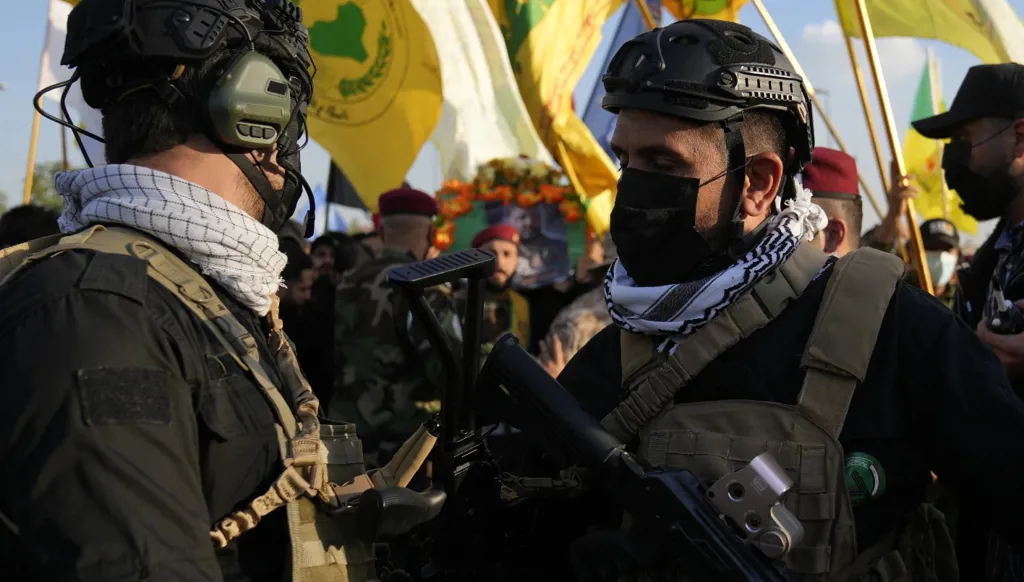 مقاتلون من الحشد الشعبي خلال تشييع قيادي في "كتائب حزب الله" في بغداد، 8 شباط/فبراير 2024. (أ ب)  