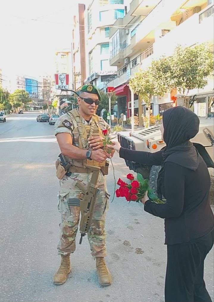 سيدة تستقبل الجيش بالورود.