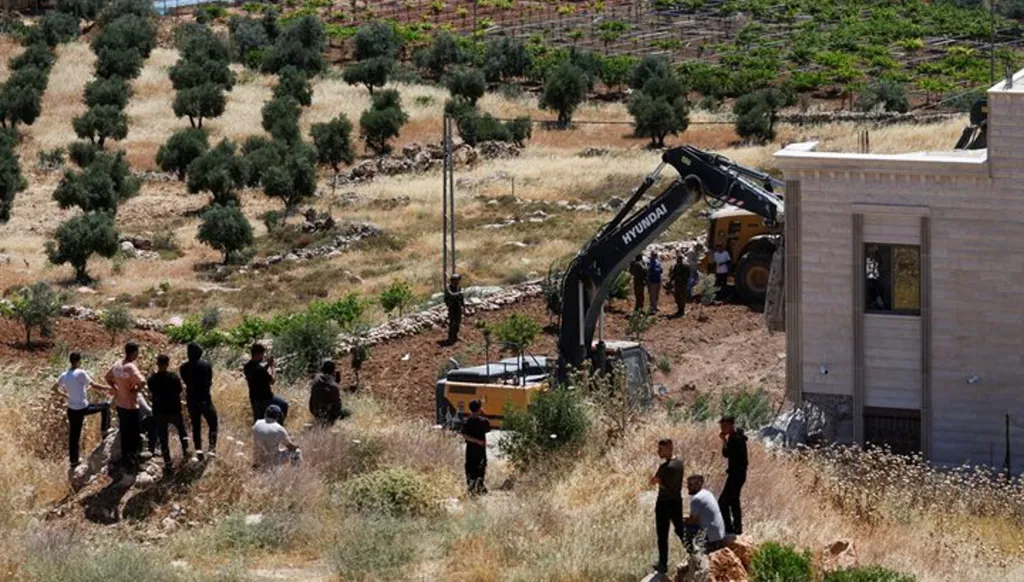 فلسطينيون يتفحصون هدم منزل فلسطيني قرب الخليل في الضفة الغربية (رويترز). 