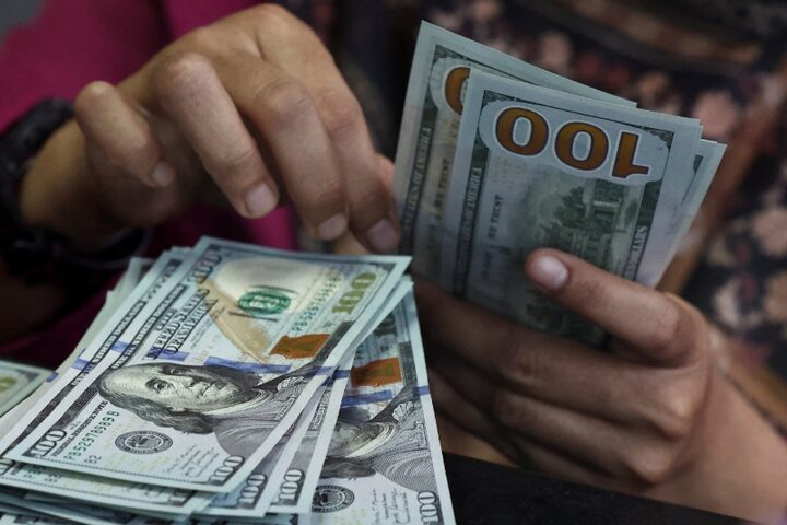 موظفة تعد أوراقاً نقدية من الدولار الأميركي في مكتب صرافة بجاكرتا. (رويترز)