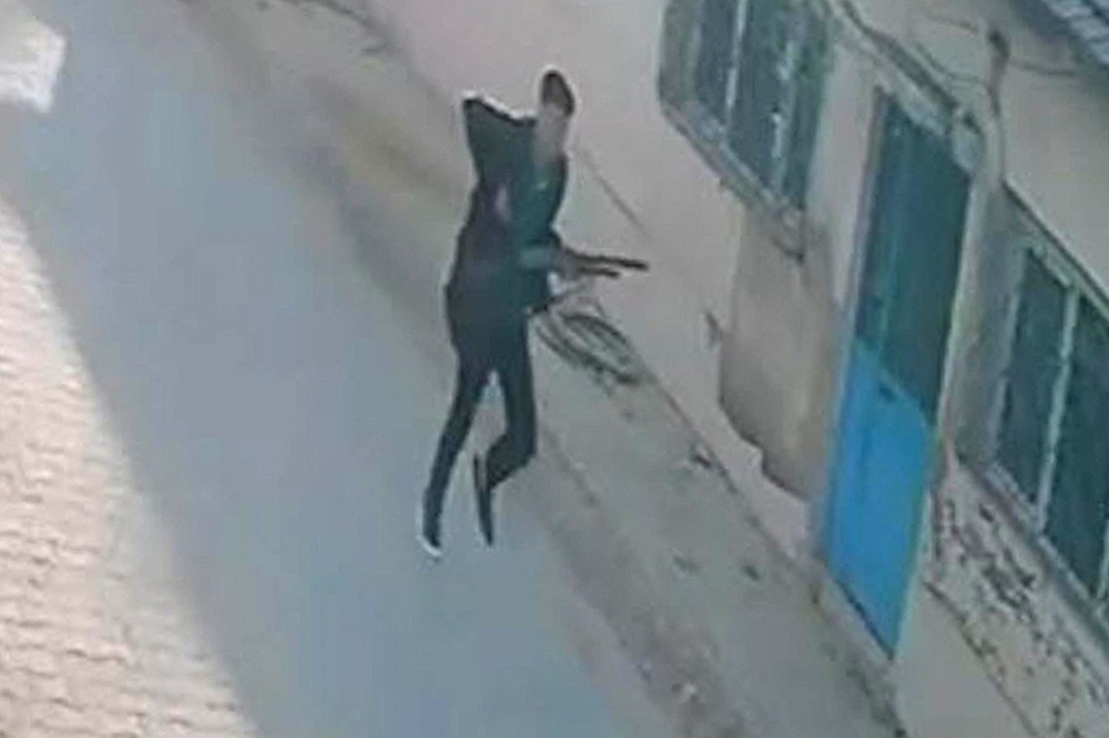 لقطةً من كاميرا مراقبة تظهر مسلحاً يركض بالقرب من مدرسة في تورغوتلو في 22 أيلول/ سبتمبر. (أ.ف.ب.)