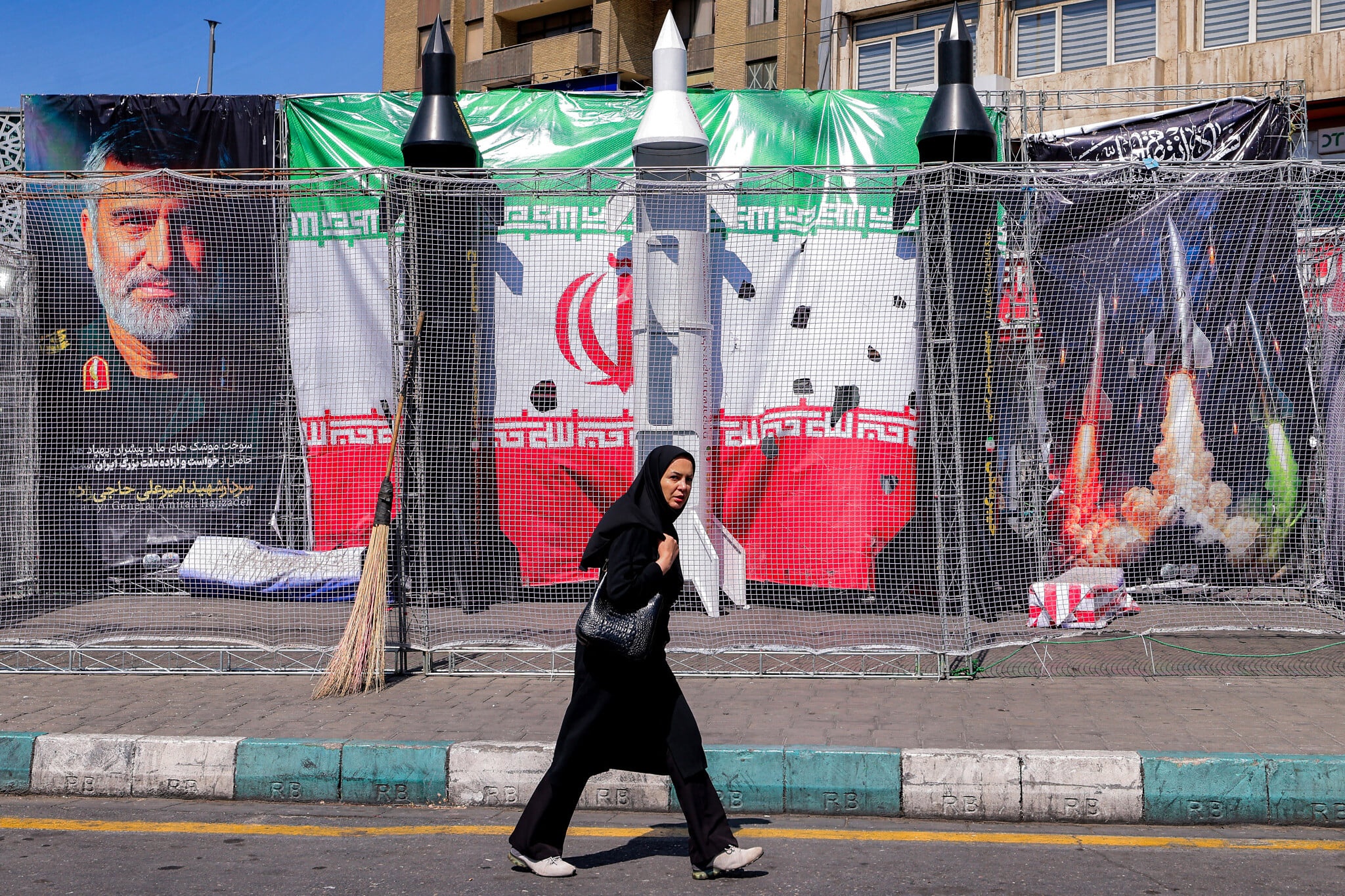 إيرانية تمر بنماذج صواريخ إيرانية معروضة في ساحة ولي العصر بطهران، 6 أبريل 2026. (أ ف ب)