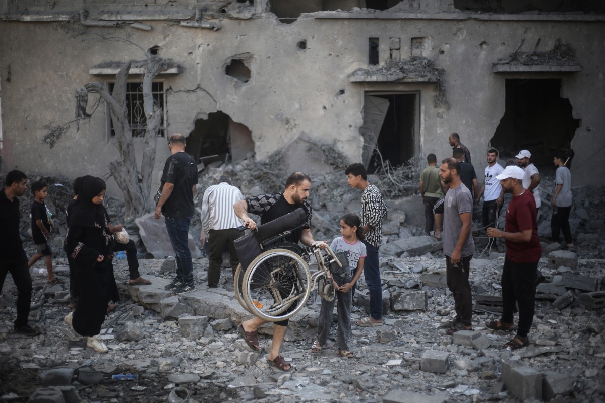 يتفقد الفلسطينيون المباني المتضررة والمدمرة بعد غارات إسرائيلية في دير البلح، وسط قطاع غزة، في 29 يوليو 2026 (أ ف ب)