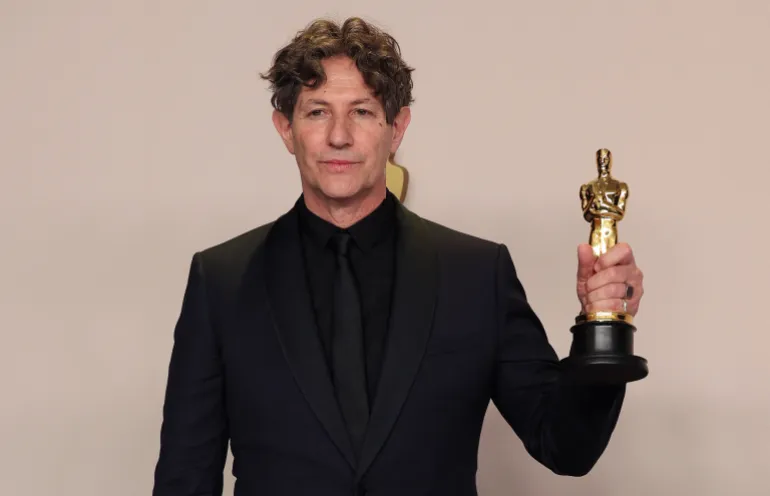 المخرج جوناثان غليزر يقف حاملا جائزة الأوسكار لأفضل فيلم روائي دولي عن فيلم