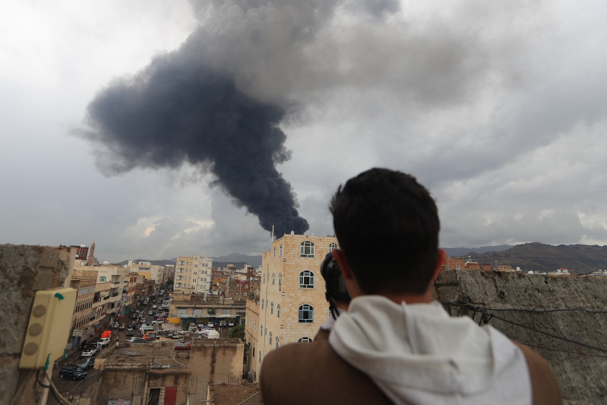 مصور يلتقط صورة للدخان بعد غارة جوية إسرائيلية على صنعاء (أ ‏ف ب)‏