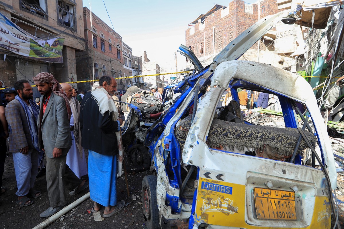 أشخاص يعاينون أضرار القصف في صنعاء (أ ف ب)‏