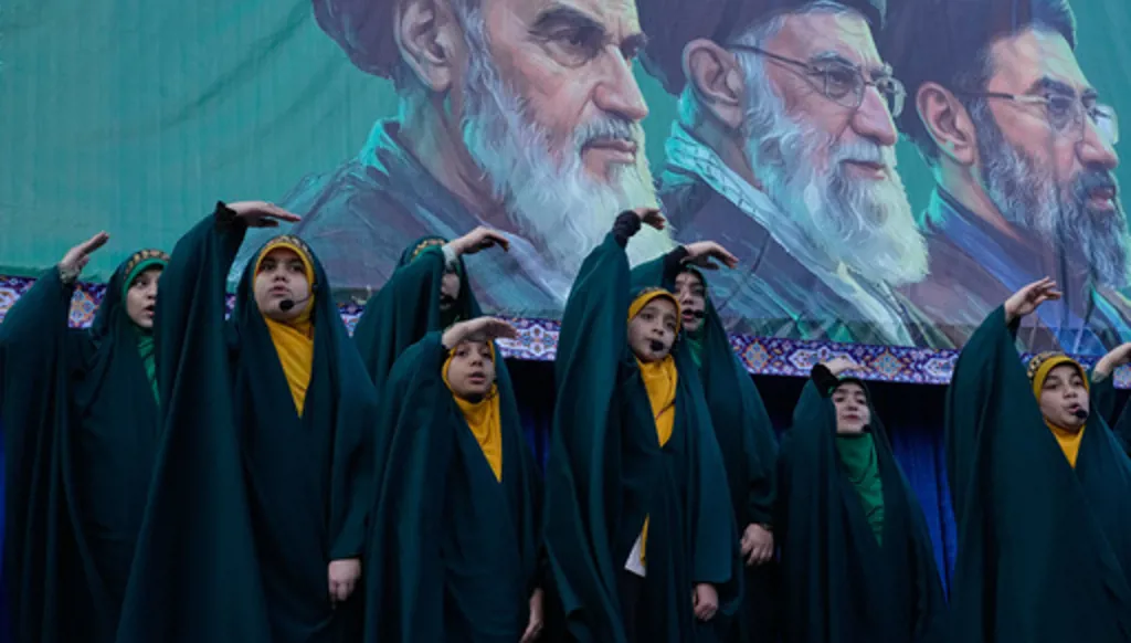 Girls sing a song as they show the movement of missiles with their hands next to the portraits of the late Iranian revolutionary founder Ayatollah Khomeini, left, late Supreme Leader Ayatollah Ali Khamenei, center, and Supreme Leader Ayatollah Mojtaba Khamenei, in a state-organised rally celebrating the birthday of Imam Reza, the 8th Shiite Muslims' Imam, and supporting the supreme leader, in Tehran, Iran, Wednesday, April 29, 2026. (AP Photo/Vahid Salemi)