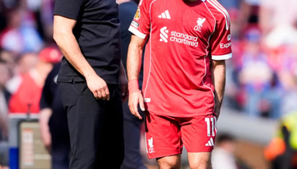 Liverpool's Mohamed Salah grabs at his leg as he speaks with with manager Arne Slot after being substituted during the Premier League soccer match between Liverpool and Crystal Palace, Saturday, April 25, 2026, in Liverpool, England. (Peter Byrne/PA via AP)