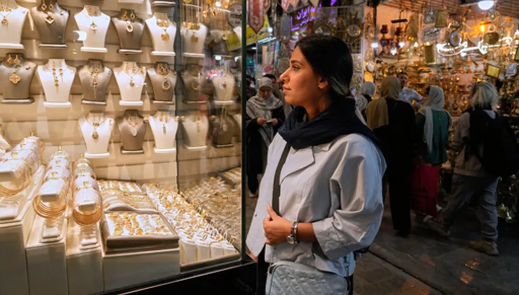 A woman looks at jewelry in the window of a gold shop at Tehran's historic Grand Bazaar, Iran, Sunday, May 3, 2026. (AP Photo/Vahid Salemi)