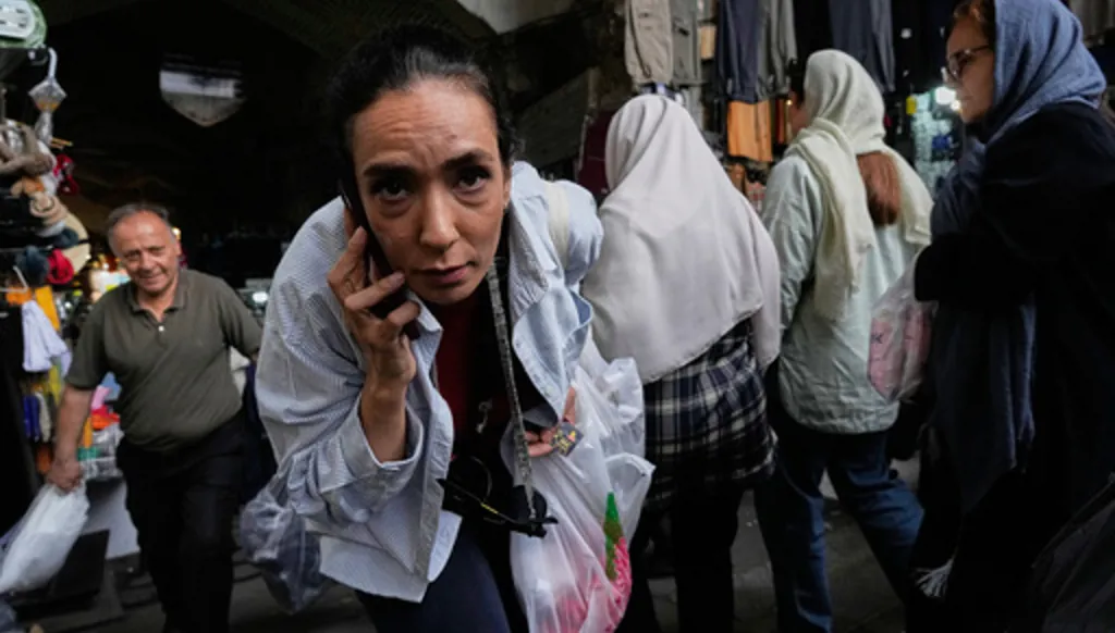 A woman reacts to the camera at Tehran's historic Grand Bazaar, Iran, Sunday, May 3, 2026. (AP Photo/Vahid Salemi)