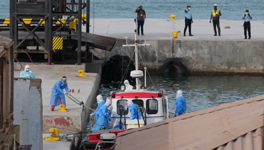 Health workers in protective gear evacuate patients from the MV Hondius cruise ship at a port in Praia, Cape Verde, Wednesday, May 6, 2026. (AP Photo/Misper Apawu)