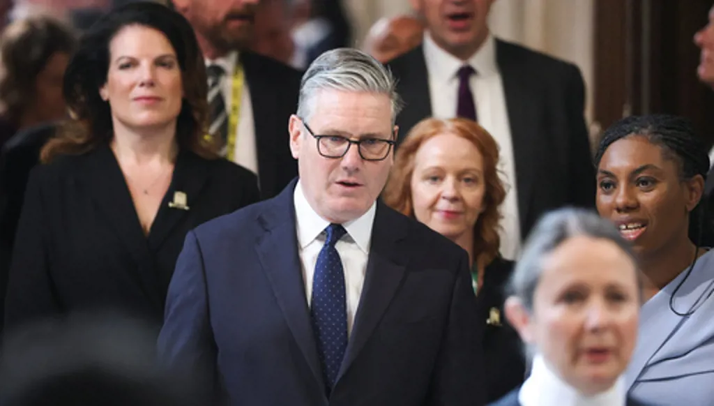 British Prime Minister Keir Starmer, center, walks through the House of Commons to attend the State Opening of Parliament at the Palace of Westminster, London, Wednesday, May 13, 2026. (Toby Melville/Pool Photo via AP)