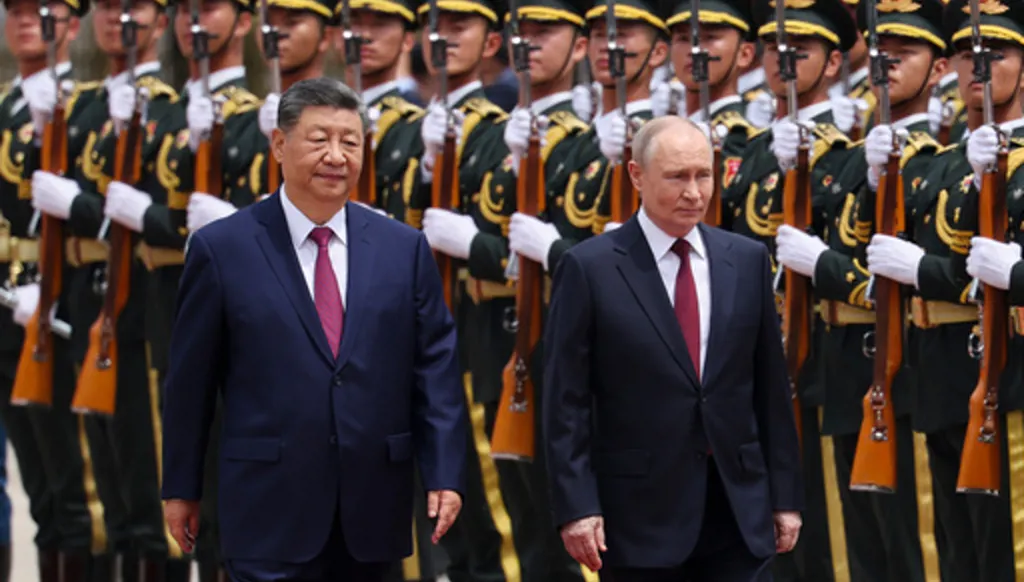 Russian President Vladimir Putin, right, and Chinese President Xi Jinping inspect an honor guard during a welcoming ceremony at the Great Hall of the People in Beijing Wednesday, May 20, 2026. (Maxim Shemetov/Pool Photo via AP)