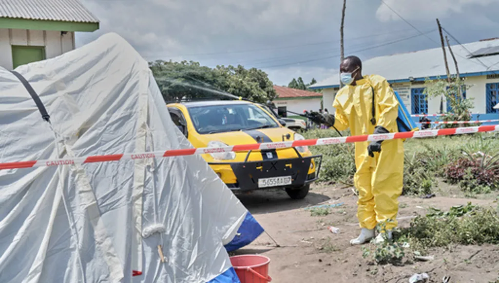 A man sprays a tent at an Ebola treatment center in Bunia, Congo, Tuesday, May 19, 2026. (AP Photo/Dirole Lotsima Dieudonne)