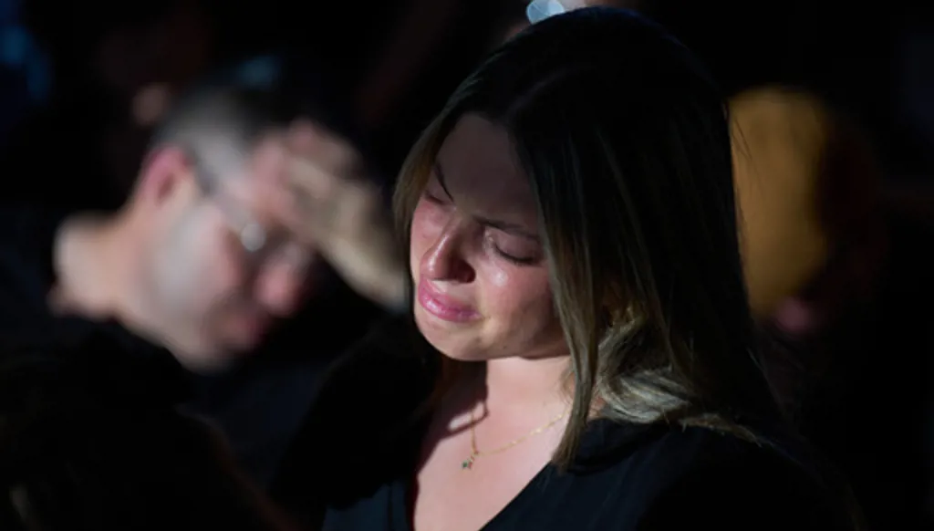 Adi, sister of Israeli soldier Staff sergeant Noam Hamburger, who was killed in a Lebanese drone attack on northern Israel, mourns over his casket during his funeral in Atlit, Israel, Sunday, May 24, 2026. (AP Photo/Ariel Schalit)