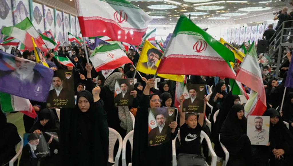 Government supporters hold Iranian flags and pictures of Iran's Supreme Leader, Ayatollah Mojtaba Khamenei, during a ceremony honoring the armed forces and those killed in the war with Israel and the U.S. at the Imam Khomeini Grand Mosque in Tehran, Iran, Sunday, May 24, 2026. (AP Photo/Vahid Salemi)
