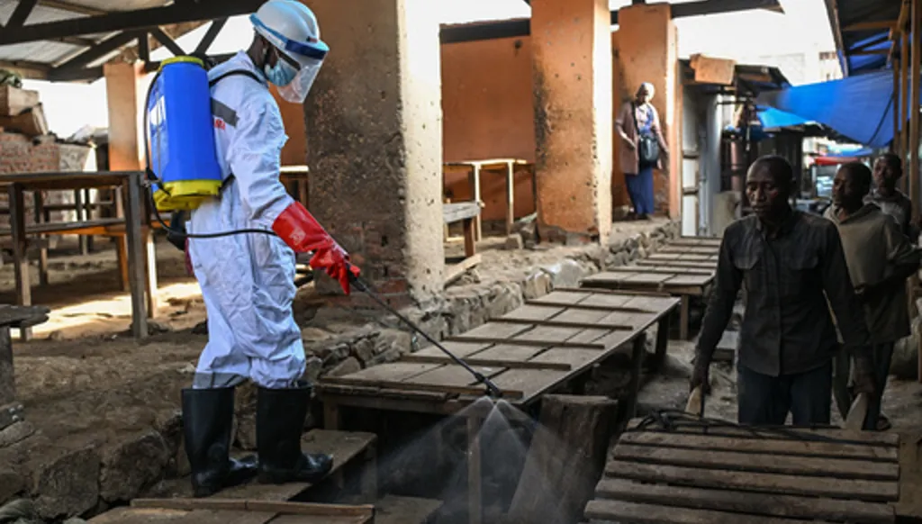 A sanitation worker from the Bunia city government sprays chlorine to disinfect the central market, as Ituri province continues to combat an Ebola outbreak, in Bunia, Congo, Saturday, May 23, 2026. (AP Photo/Moses Sawasawa)