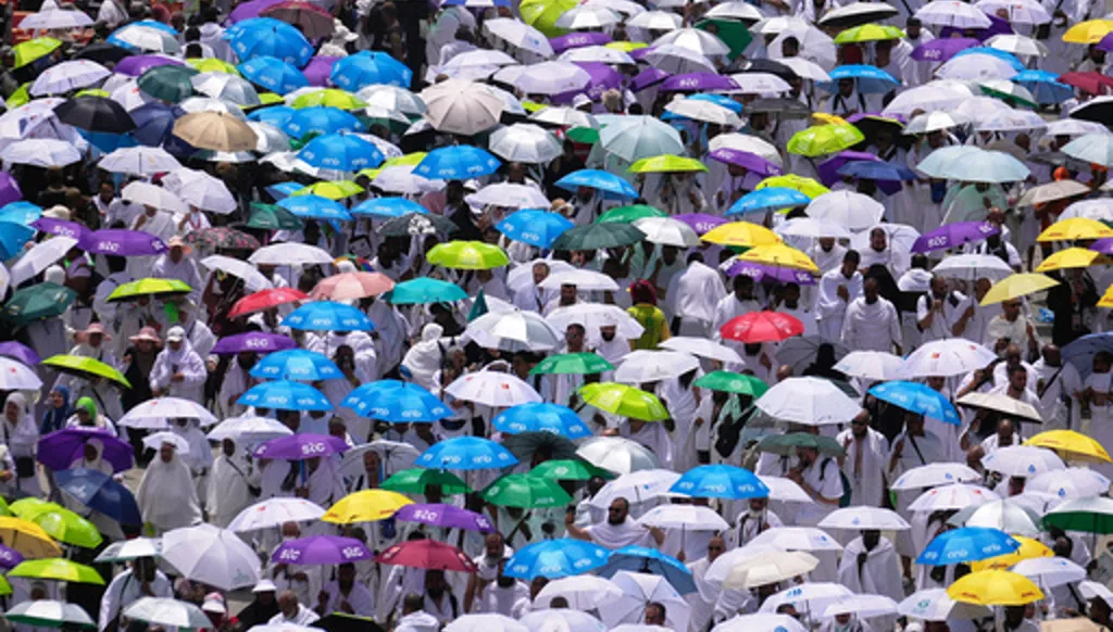 Muslim pilgrims hold umbrellas as they leave after offering noon prayers at Namirah mosque during the annual Hajj pilgrimage on the Plain of Arafat, near the holy city of Mecca, Saudi Arabia, Tuesday, May 26, 2026. (AP Photo/Altaf Qadri)
