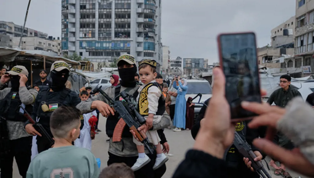 Palestinians take photos with Islamic Jihad militants as they gather for Eid al-Adha prayers in Gaza City Wednesday, May 27, 2026. (AP Photo/Jehad Alshrafi)
