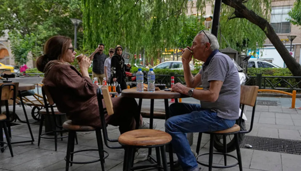 People drink coffee in the al fresco dining area of a cafe near the old main bazaar of Tehran, Iran, Thursday, May 28, 2026. (AP Photo/Vahid Salemi)