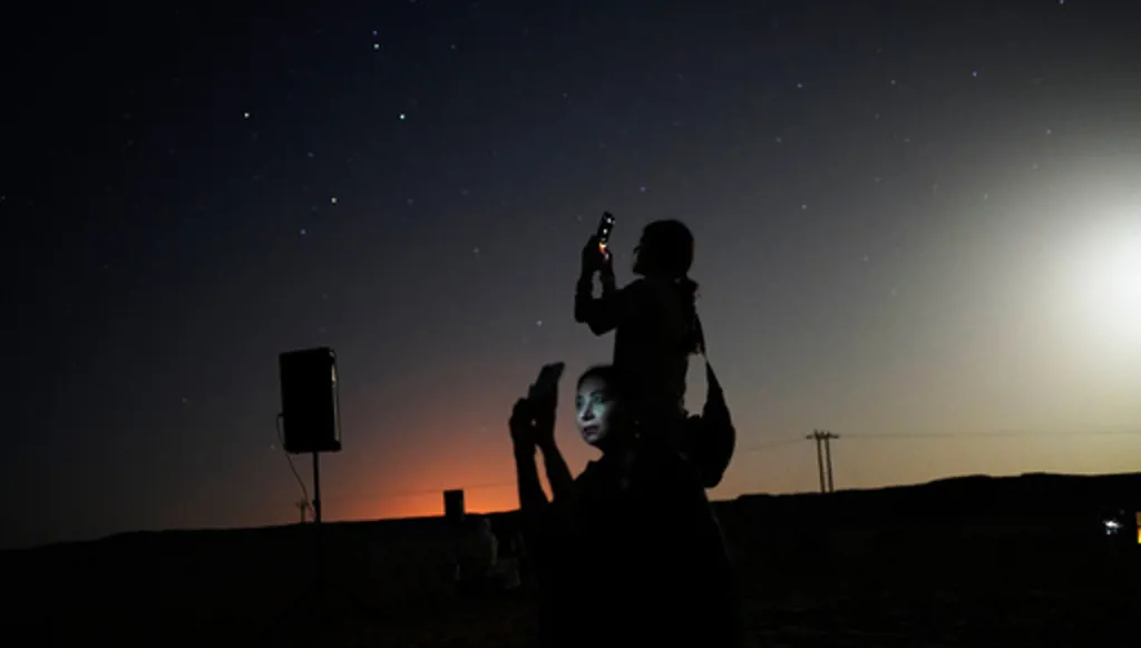 This long-exposure photograph shows women taking mobile phone pictures in the Al Quaa Desert outside of Abu Dhabi, United Arab Emirates, Saturday, May 23, 2026. (AP Photo/Jon Gambrell)