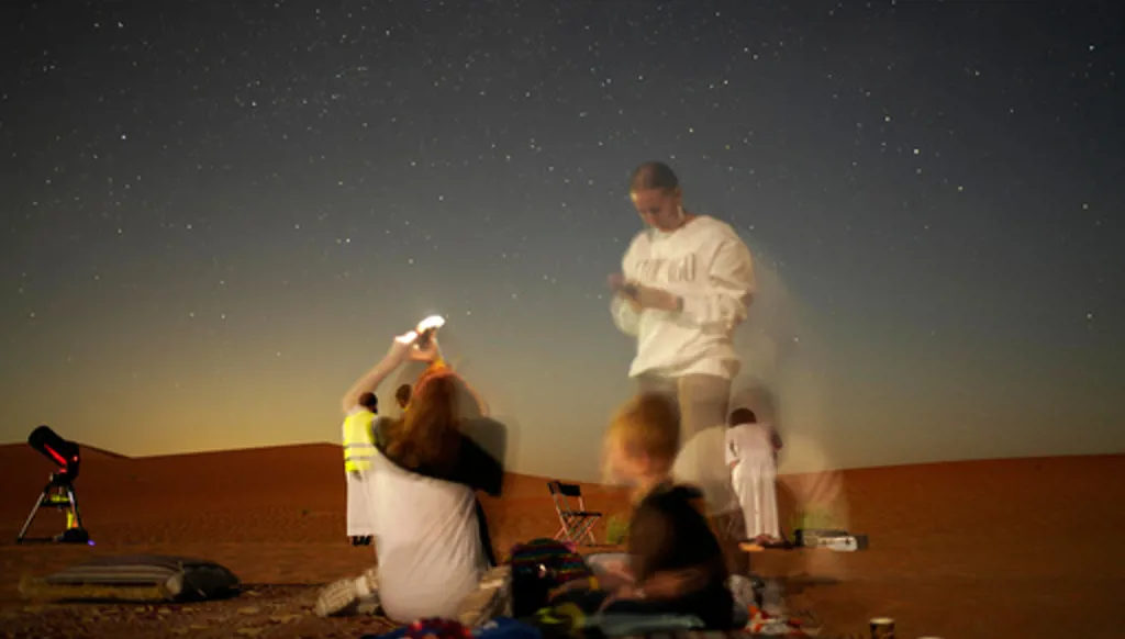 This long-exposure photograph shows a family taking mobile phone pictures in the Al Quaa Desert outside of Abu Dhabi, United Arab Emirates, Saturday, May 23, 2026. (AP Photo/Jon Gambrell)