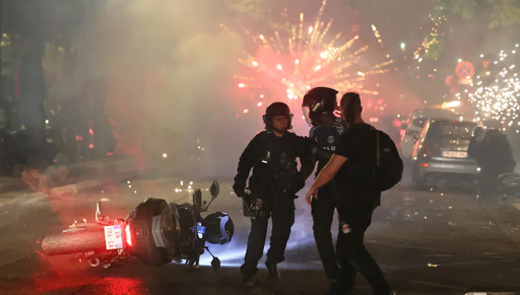 Police try to disperses PSG supporters who left off fireworks as they celebrate in Paris, Saturday, May 30, 2026 after the Champions League final soccer match between Paris Saint-Germain and Arsenal that was played in Budapest, PSG won the game. (AP Photo/Thomas Padilla)