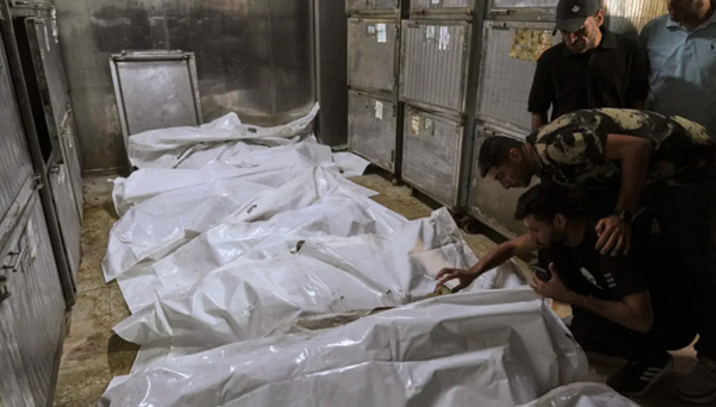Palestinians mourn over the bodies of people killed in an Israeli strike, before their funeral in the morgue of Shifa Hospital in Gaza City, Thursday, June 4, 2026. (AP Photo/Jehad Alshrafi)