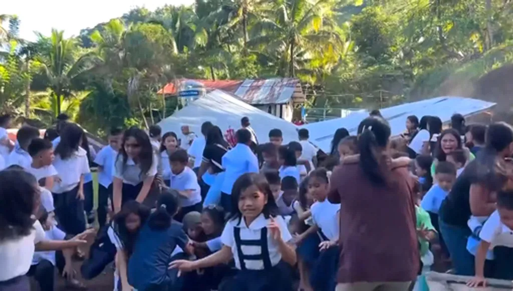 This image made from video provided by DepEd Mahayahay Elementary School shows school children reacting as a canopy roof, rear, collapsed, caused by a powerful earthquake Monday, June 8, 2026, in Malita, Davao Occidental Province, Philippines. (DepEd Mahayahay Elementary School via AP)