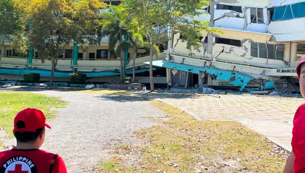 In this photo provided by the Philippine Red Cross, rescuers inspect the damage to Notre Dame of Dadiangas University after an earthquake in General Santos, Philippines, Monday, June 8, 2026. (Philippine Red Cross via AP)